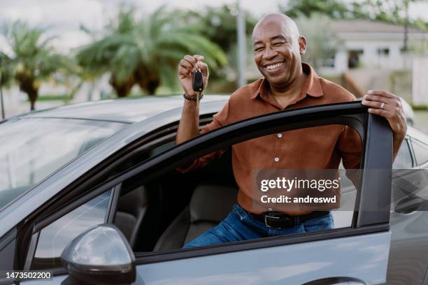 sosteniendo la llave del auto nuevo - friendly salesman fotografías e imágenes de stock