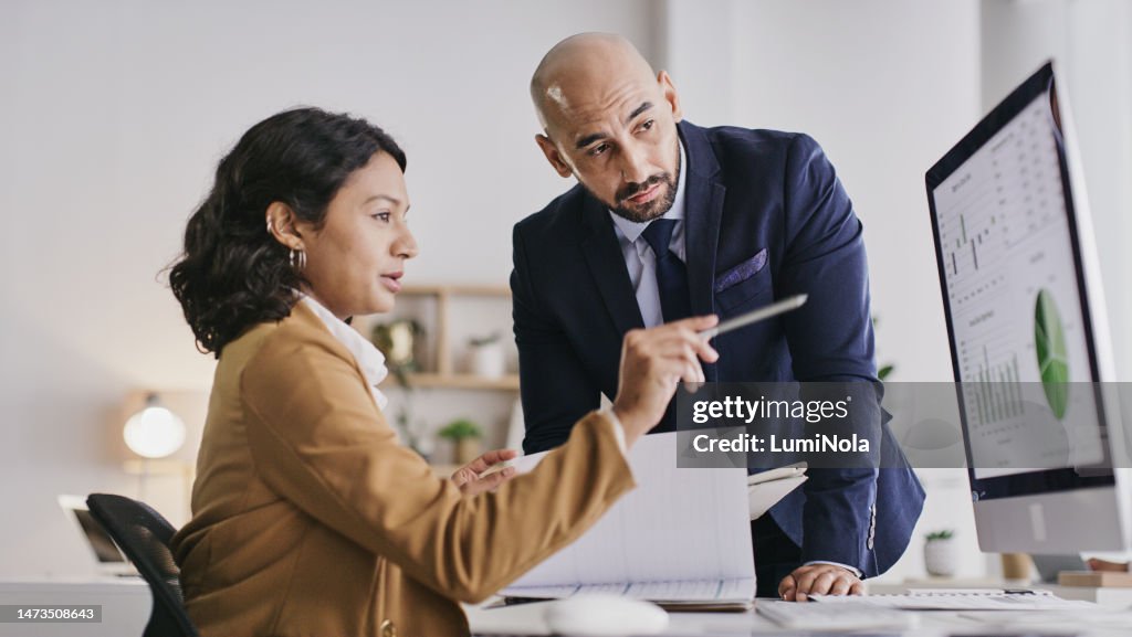 Business people, computer and analytics monitoring corporate statistics of graph or chart on screen at office. Businessman and woman in teamwork collaboration on company data or analysis on PC