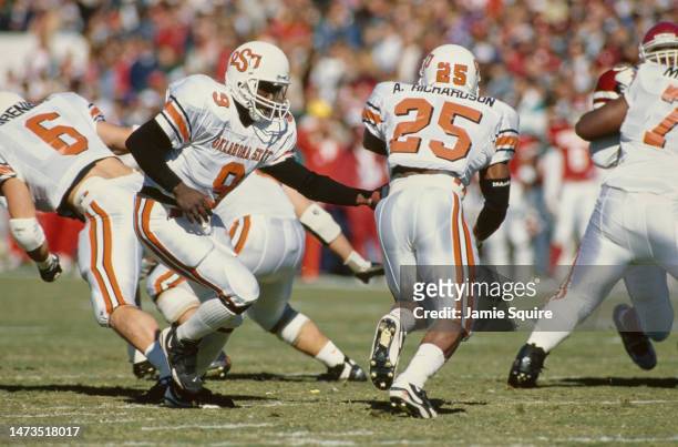 Tone Jones, Quarterback for the Oklahoma State Cowboys hands off the football to the running back Andre Richardson during the NCAA Big 8 Conference...