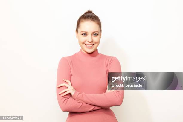portrait en studio d’une jeune belle femme blanche gaie aux cheveux bruns dans une robe rose sur fond blanc - manches longues photos et images de collection