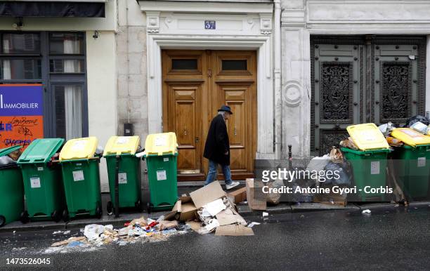 People walk past pilled garbage bags piled up on the street during the garbage collectors' strike on March 14, 2023 in Paris, France. Uncollected...