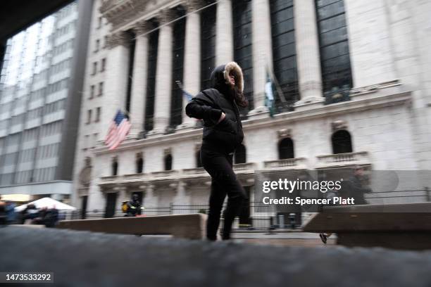 People walk through lower Manhattan by the New York Stock Exchange in light snow on March 14, 2023 in New York City. Much of the Northeast is being...