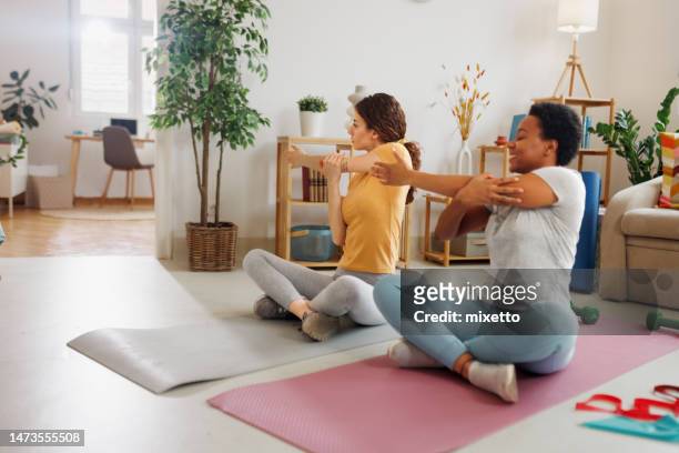 female friends working out together at home - floor gymnastics bildbanksfoton och bilder