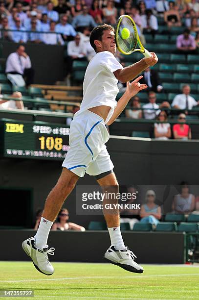 Britain's James Ward plays a forehand shot during his second round men's singles match against US player Mardy Fish on day four of the 2012 Wimbledon...