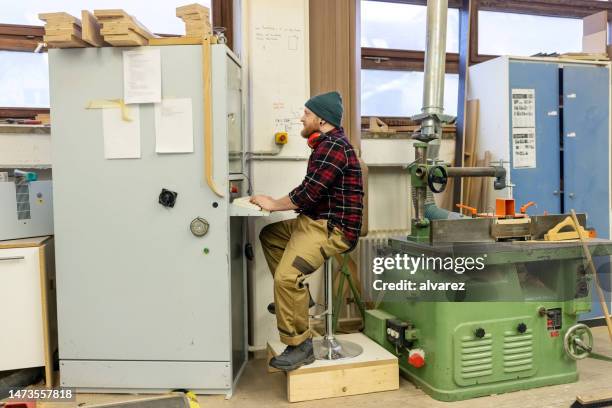 möbelfabrikarbeiter programmiert eine cnc-maschine mit einem computer - cnc machine for wood stock-fotos und bilder