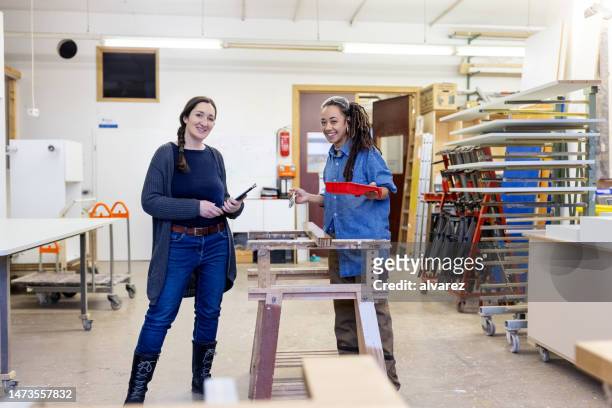 portrait of a furniture factory manager with female worker varnishing wood - quality control stock pictures, royalty-free photos & images