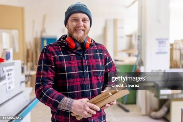 portrait of carpenter working at woodworking shop - woodwork stock pictures, royalty-free photos & images