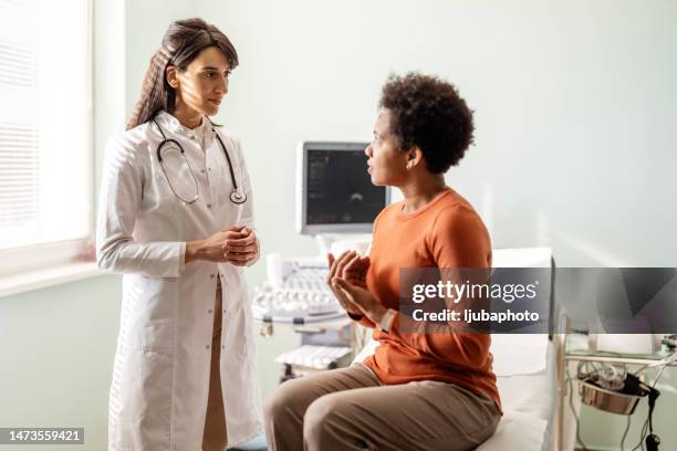 a female doctor talks with her patient in front of her as they talk about her concerns. - screening of ill see you in my dreams arrivals stockfoto's en -beelden