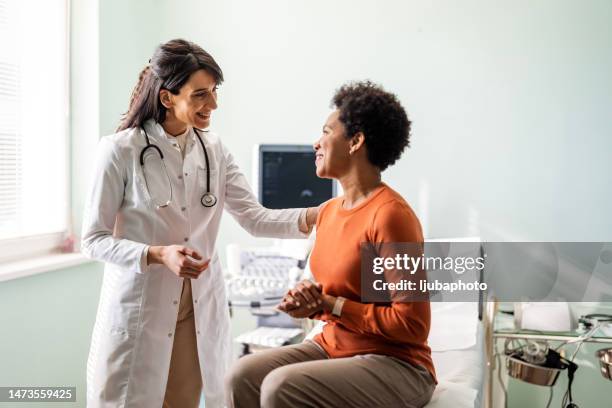 medico donna che rassicura un paziente - adult patient with doctor and stethoscope foto e immagini stock