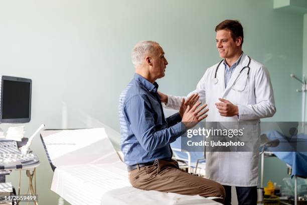 caring doctor listens to patient - male doctor man patient stockfoto's en -beelden