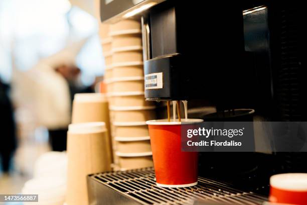 automatic coffee machine in a self-service restaurant, preparing various types of coffee hot drinks. red paper disposable coffee cups to go. fast food cafeteria - koffiemachine stockfoto's en -beelden