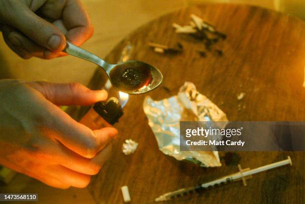 In this photo illustration a model recreates the cooking up of heroin in a spoon prior to injecting it with a needle, on June 01, 2005 in Bristol,...