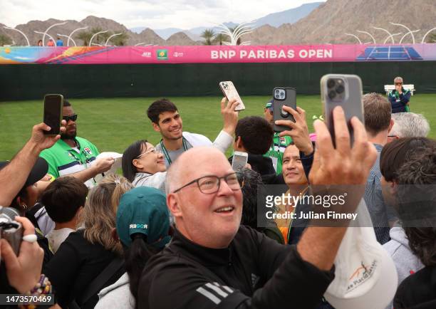 Carlos Alcaraz of Spain has his photo taken with fans during BNP Paribas Open on March 14, 2023 in Indian Wells, California.