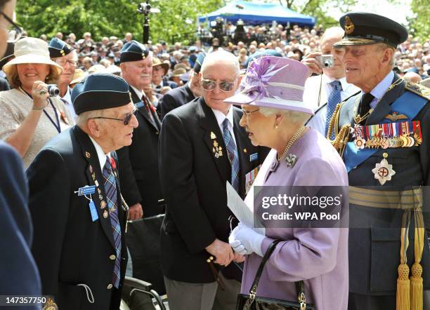 Queen Elizabeth II and Prince Philip, Duke of Edinburgh talk to WWII veteran Ed Carter-Edwards, a former member of Bomber Command from Canada, after...