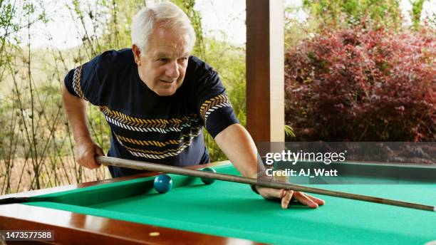 retired man playing billiards in patio - old pool table stock pictures, royalty-free photos & images