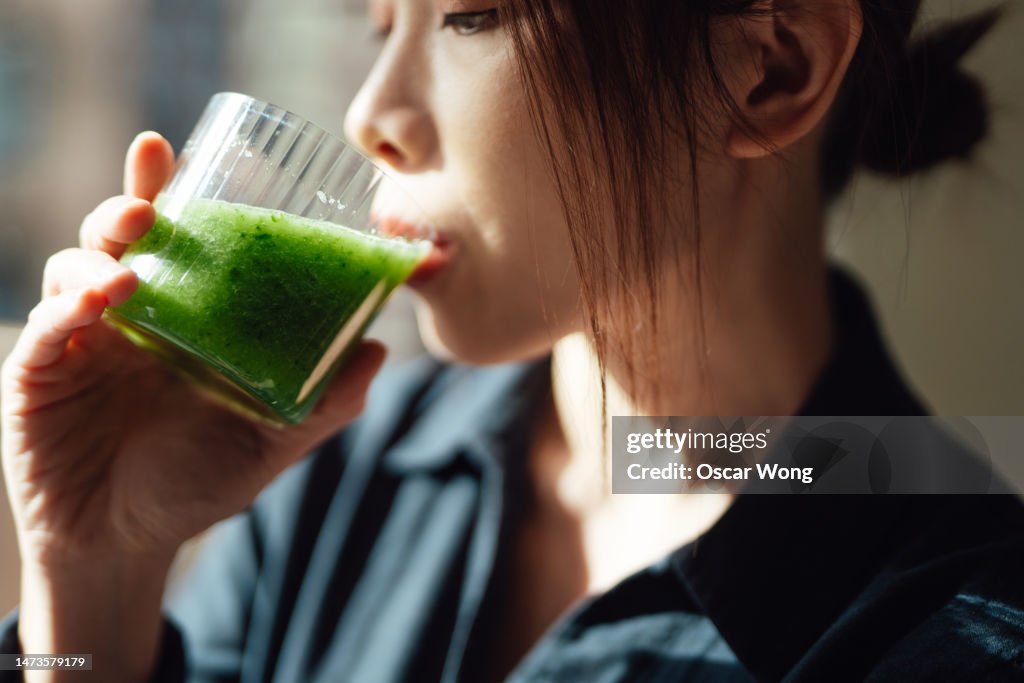 Close-up of young Asian woman drinking healthy detox for a healthy living