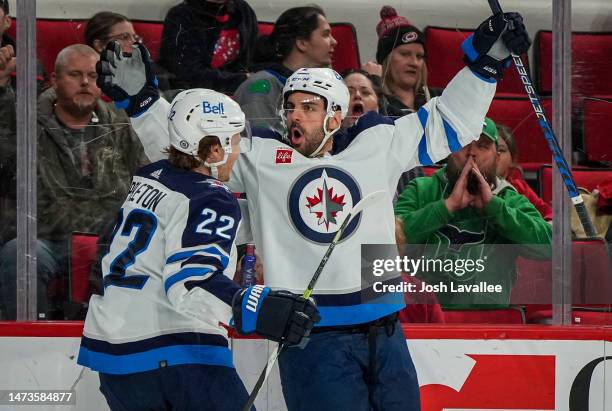 Dylan DeMelo of the Winnipeg Jets celebrates with Mason Appleton after a goal during the second period against the Carolina Hurricanes at PNC Arena...