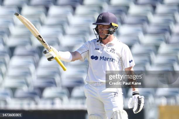 Marcus Harris of Victoria raises his bat after reaching his half century during the Sheffield Shield match between Western Australia and Victoria at...