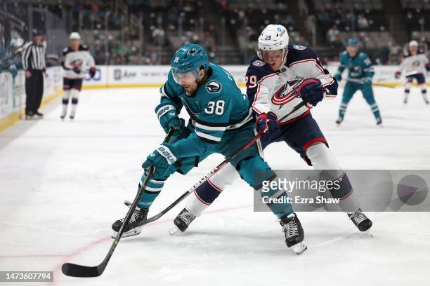 Mario Ferraro of the San Jose Sharks and Patrik Laine of the Columbus Blue Jackets go for the puck in the first period at SAP Center on March 14,...