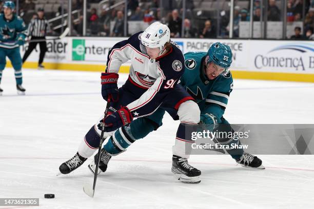 Kent Johnson of the Columbus Blue Jackets and Derrick Pouliot of the San Jose Sharks go for the puck in the third period at SAP Center on March 14,...