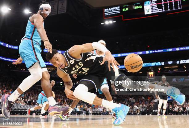 Giannis Antetokounmpo of the Milwaukee Bucks loses the ball as he drives against Josh Okogie of the Phoenix Suns during the second half of the NBA...