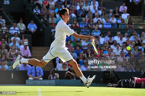 Britain's James Ward plays a shot during his second round men's singles defeat to US player Mardy Fish on day four of the 2012 Wimbledon...