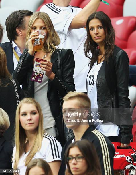 Sarah Brandner girlfriend of Bastian Schweinsteiger, Lisa Mueller wife of Thomas Mueller look on during the UEFA EURO 2012 semi final match between...