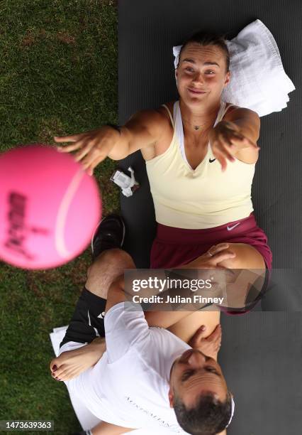 Aryna Sabalenka signs autographs whilst stretching during BNP Paribas Open on March 14, 2023 in Indian Wells, California.