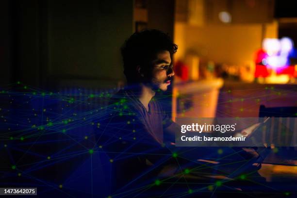 young computer programmer working on his computer at night with technology background - it programmer stock pictures, royalty-free photos & images