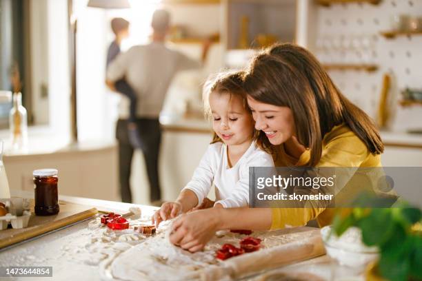 happy mother and daughter making cookies in the kitchen. - mother daughter baking stock pictures, royalty-free photos & images