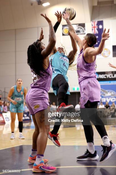 Kayla Thornton of the Flyers shoots against Tiffany Mitchell of the Boomers and Cayla George of the Boomers during the round three WNBL match between...