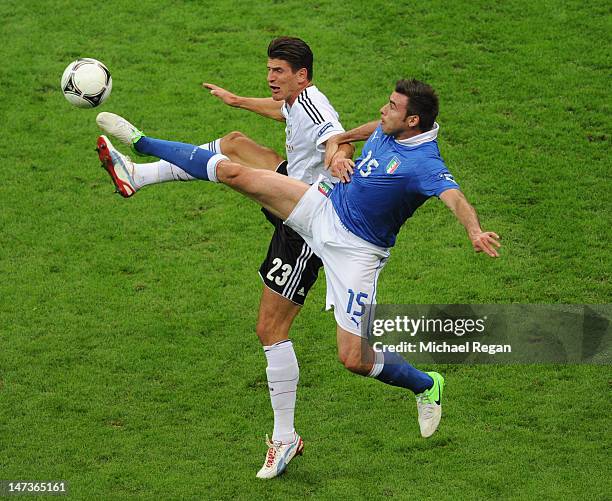 Andrea Barzagli of Italy challenges Mario Gomez of Germany during the UEFA EURO 2012 semi final match between Germany and Italy at National Stadium...