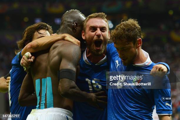 Mario Balotelli of Italy celebrates with team-mates Claudio Marchisio and Daniele De Rossi after scoring his team's second goal during the UEFA EURO...