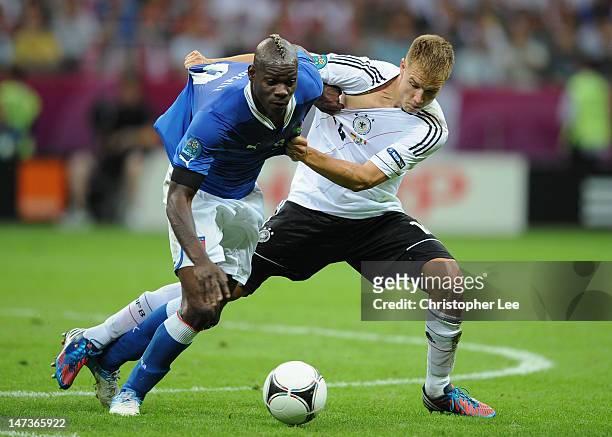 Mario Balotelli of Italy battles for the ball with Holger Badstuber of Germany during the UEFA EURO 2012 semi final match between Germany and Italy...
