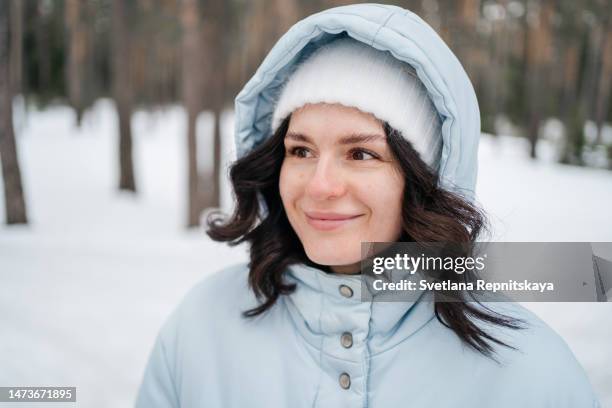 woman in warm clothes in snowy spring forest - kapstaden stockfoto's en -beelden