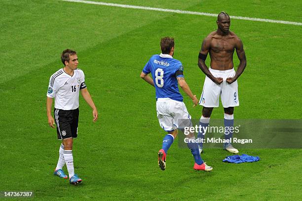 Mario Balotelli of Italy celebrates with team-mate Claudio Marchisio after scoring his team's second goal as Philipp Lahm of Germany shows his...