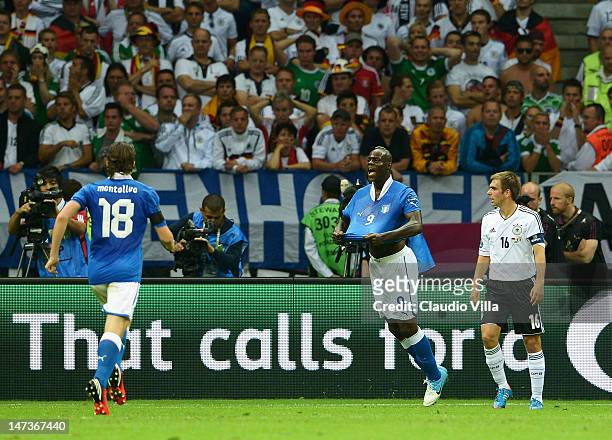 Mario Balotelli of Italy celebrates scoring the opening goal as Philipp Lahm of Germany shows his dejection during the UEFA EURO 2012 semi final...