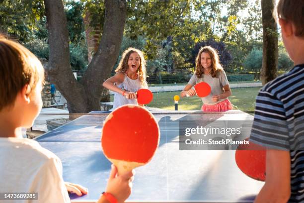 children playing table tennis on summer day - table tennis paddle stockfoto's en -beelden