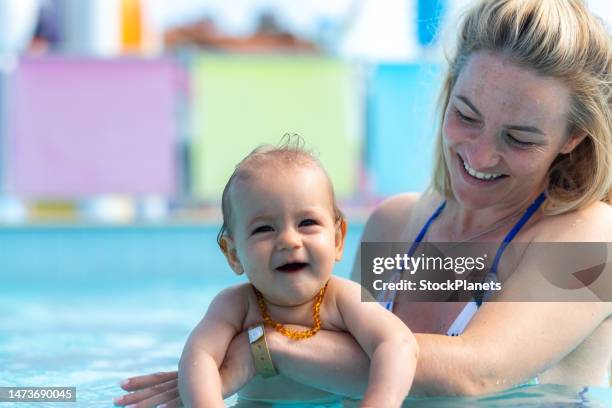mutter und kleines mädchen genießen im pool - baby schwimmen stock-fotos und bilder