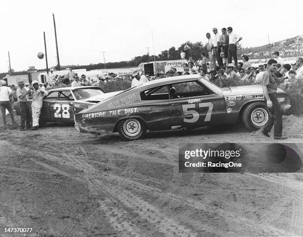 August 18, 1968: Earl Brooks starts to remove his helmet next to his battered 1966 Ford after he tangled with Ervin Pruitt’s 1967 Dodge Charger...