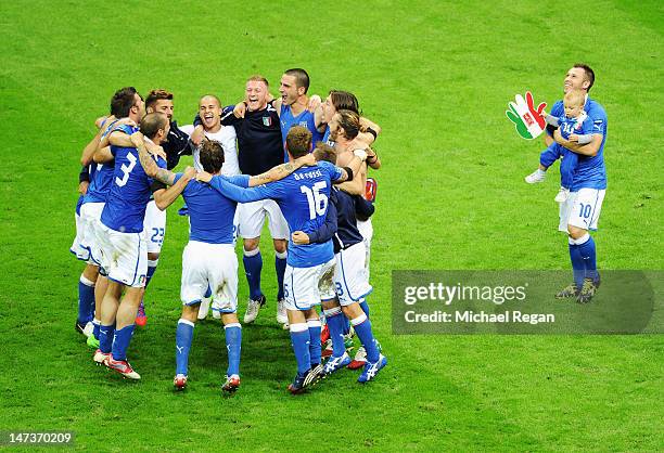 Antonio Cassano of Italy carries his son Christopher Cassano as his team-mates celebrate victory after the UEFA EURO 2012 semi final match between...