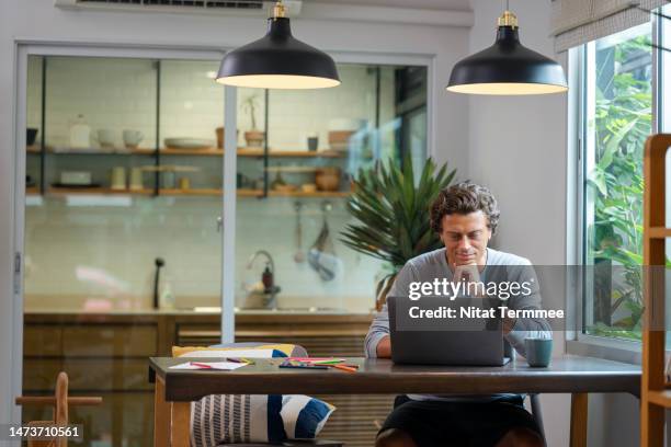 remote locations, working with flexibility in work from anywhere solutions. software developer using a laptop computer to design computer applications and software quality assurance analysts and testers in the living room at home. - teletrabajo fotografías e imágenes de stock