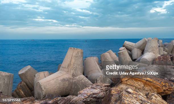 concrete breakwaters old breakwaters protection from waves at sea - groyne stock pictures, royalty-free photos & images