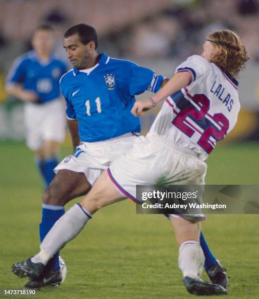 Romário, Forward for Brazil in motion is tackled by Alexi Lalas, Center Back for the United States during their Semi-Final match at the 1998 CONCACAF...