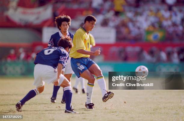 Rivaldo, Midfielder and Forward for Brazil kicks the ball up field past the defending Toshihiro Hattori of Japan during their Men's Olympic Football...