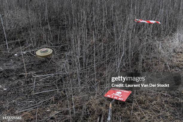 Sign on a field strewn with anti-tank mines marked out by DSNS deminer on March 3,2023 around Lyman, Ukraine. Last February, Russia's military...