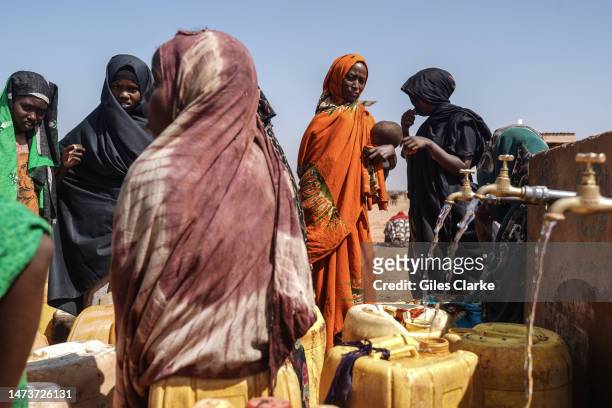 Displaced Somali women fill jerrycans with water provided in an IDP settlement on January 12,2023 in Doolow, western Somalia.