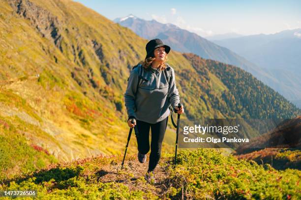 female hiker during a walk in the mountains on a sunny day - müde frühling stock-fotos und bilder