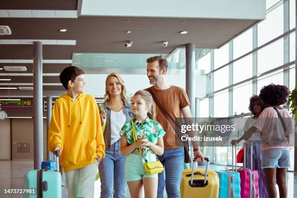 family standing at airport terminal - family summer holiday stock pictures, royalty-free photos & images