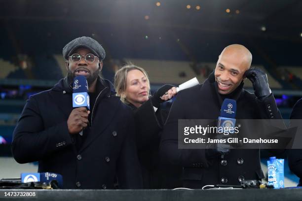 Sports pundits Micah Richards and Thierry Henry reacts as they prepare to go on air during the UEFA Champions League round of 16 leg two match...